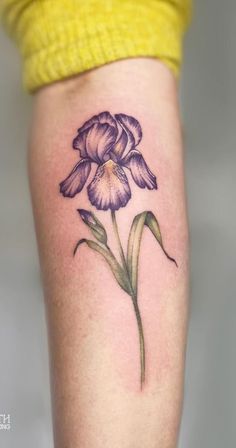 a purple flower tattoo on the leg