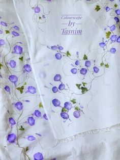 purple flowers on white fabric with green leaves and words written in blue ink above them