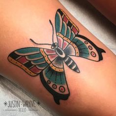 a colorful butterfly tattoo on the right thigh and lower leg, it's wings spread out