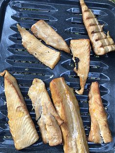 fish fillets are being cooked on a grill