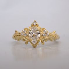 a yellow gold ring with a pear shaped diamond