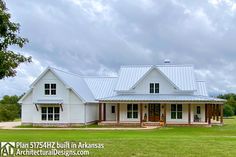 a large white house sitting on top of a lush green field