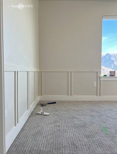 an empty room with a window and some paint on the floor in front of it