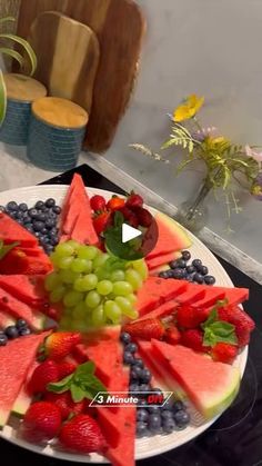 a plate with watermelon, grapes and strawberries on it