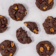 chocolate cookies with walnuts and macaroni flakes on a white marble surface