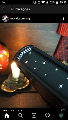 a candle is lit on a table next to a glass plate with stars painted on it