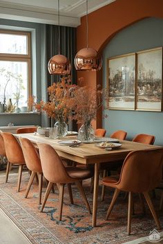 a dining room table surrounded by orange chairs and vases with flowers in them on an area rug