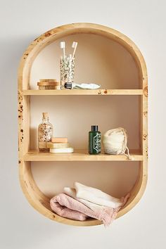 the shelves are made out of wood and have soaps, toothbrushes, and other items on them