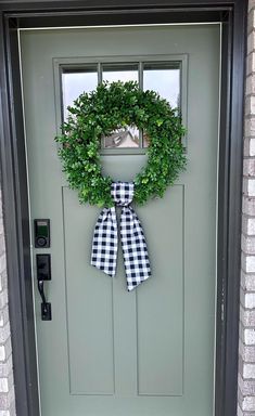 a green door with a black and white checkered bow on it