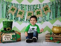 a little boy sitting in front of some st patrick's day decorations