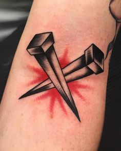 a black and red tattoo on the arm of a person with a knife in it