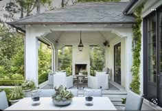 an outdoor dining area with white furniture and greenery