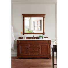 a bathroom vanity with a mirror above it and a wooden cabinet under the sink in front of it