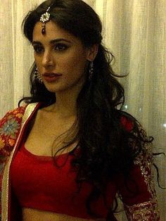 a woman in a red sari is posing for the camera