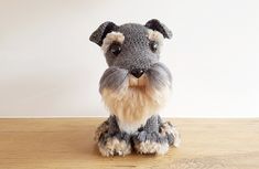 a stuffed animal dog sitting on top of a wooden table