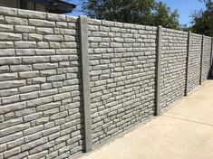 a concrete block wall next to a sidewalk