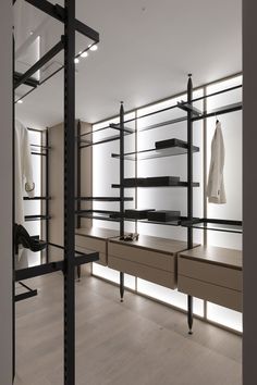 an empty walk in closet with shelves and clothes