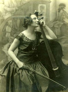 an old photo of a woman holding a cello