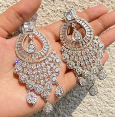 Diamond Earrings featuring semi precious CZ and diamonds. Ideal to pair with your indi western sarees and formal outfits. These earrings chendelier design will elevate your look. Perfect gift for her and gift for sister. *𝐏𝐑𝐎𝐃𝐔𝐂𝐓 𝐃𝐄𝐓𝐀𝐈𝐋* * 𝐌𝐚𝐭𝐞𝐫𝐢𝐚𝐥: Brass * 𝐏𝐥𝐚𝐭𝐢𝐧𝐠: White Rhodium  Plated * 𝐒𝐭𝐨𝐧𝐞: AAA-quality CZ Diamond. *𝐃𝐈𝐌𝐄𝐍𝐒𝐈𝐎𝐍𝐒* * 𝐖𝐞𝐢𝐠𝐡𝐭: 23 gm each * 𝐂𝐥𝐨𝐬𝐮𝐫𝐞: Push Back 𝐕𝐢𝐬𝐢𝐭 𝐎𝐮𝐫 𝐅𝐀𝐐𝐬 𝐟𝐨𝐫 𝐒𝐡𝐢𝐩𝐩𝐢𝐧𝐠 𝐏𝐨𝐥𝐢𝐜𝐢𝐞𝐬 Diamond Chandbali Earrings, Western Sarees, Diamond Chandbali, Earrings Chandbali, American Diamond Earrings, Chandbali Earrings, Formal Outfits, India Jewelry, Chandelier Design