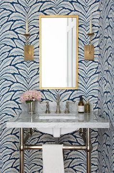 a white sink sitting under a bathroom mirror next to a wall mounted faucet