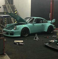 a blue car with its hood open in a garage