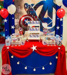 the table is decorated with red, white and blue decorations for an avengers birthday party