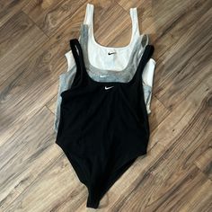 Set Of Nike Cotton Bodysuits (1 Black + 1 White + 1 Grey) All Three Are Size Women’s Medium Black Was Gently Worn Once But The White & Grey Have Never Been Worn & All Of Them Are In Good Condition. White & Grey New Without Tags So They’re Practically New Regular Price Is $35 Each But I Am Selling All Three As A Set For $60 #Nike #Nikebodysuit #Nikeclothes #Bodysuits Nike Sets, Nike Sleeveless Sports Bra With Go-dry, Cheap Nike Sports Bra With Moisture-wicking, Nike Sports Bra With Moisture-wicking Medium Support, Nike Go-dry Sportswear Tank Top, Nike Stretch Moisture-wicking Tank Top, Cotton Bodysuit, Womens Bodysuit, Nike Tops