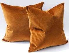 two brown pillows sitting next to each other