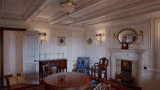 an old fashioned dining room with chairs and a table in front of a fire place