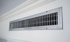 an air conditioner mounted on the side of a wall in a room with white walls