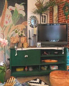 a living room filled with furniture and a flat screen tv on top of a green cabinet