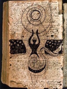 an old book with drawings on it and writing in black ink, sitting on top of a