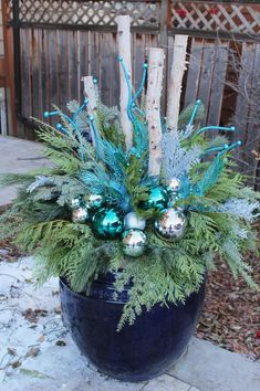 a potted plant with blue and green ornaments in it's center, sitting on a patio