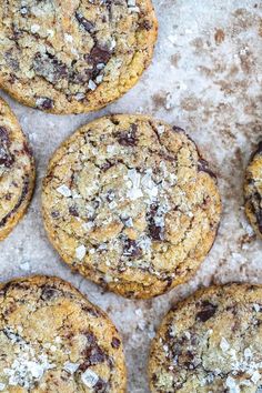 chocolate chip cookies are arranged on a baking sheet with crumbs and powdered sugar