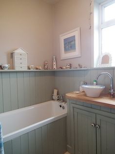 a bathroom with a sink, bathtub and window