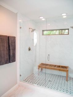 a bathroom with a bench and shower in it