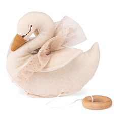 a white stuffed swan with a wooden toy on its neck and head, sitting next to it's body