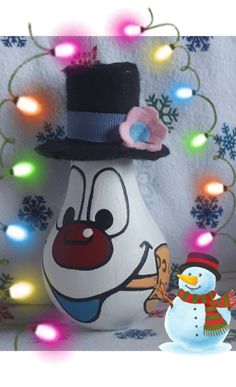 a snowman with a top hat and scarf next to a light - up christmas decoration