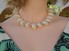 This beautiful necklace are made of pearlized turbo cinerus shells and freshwater pearl beads. Gorgeous and unique! Great idea for gift! 🎁 Necklaces - Length : approximately 16" long, strung with professional quality "Accu-Flex" 49 strands softest drape beading wire. Finished with 18k real gold plated toggle clasp. - Shells : approximately 25mm white turbo cinerus shells and 5mm freshwater pearl. - These are made of natural organic real seashells, blemishes or imperfections are part of its characteristics. - Each natural seashell has its own uniqueness, however, you will receive the same quality seashell as in photo. - Your jewelry will be carefully packaged to ensure safe arrival. Shipping 📦 - I send this order with standard shipping! The estimate delivery date for standard shipping is Elegant Shell-shaped Pearl Necklace For Beach, Elegant Pearl Charm Shell Necklace, Elegant Shell Pearl Necklace With Pearl Charm, Elegant Pearl Necklace With Shell And Pearl Charm, Unique Pearl Necklace For Wedding, Pearl Shell-shaped Necklace Gift, Pearl Shell Necklace For Gifts, Pearl Shell-shaped Necklace For Gift, Pearl Shell Necklace For Gift