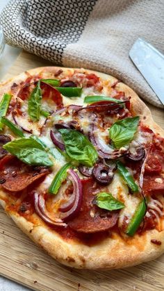 a pizza sitting on top of a wooden cutting board