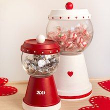 two red and white candy dispensers sitting on top of a table