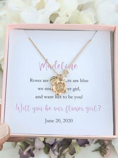 a personalized necklace in a pink box with flowers on the side and a message below it