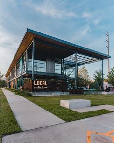 a building with a sign that reads local on the side and grass in front of it