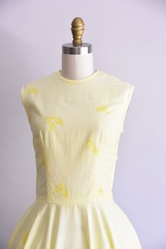 "Vintage 1950s cotton handmade dress. Pale yellow with sizable rose print at border and falling leaves throughout. Scoop collar, sleeveless, and nipped waist. Full skirt. Back and side metal zipper closure. \"American Beauty\" printed on inner seams of dress. State of garment | very good, light overall fading and faint staining on skirt (hard to detect). Measurements ✂--- Best fit | Small Bust | max 35.5\" Shoulders | 15\" Shoulder to waist | 18\" *best fit for someone with a longer torso Sleeve Yellow 1950s Sleeveless Dress, Yellow 1950s Style Sleeveless Dress, Yellow Sleeveless 1950s Dress, Sunshine Dress, Morgan Dress, Tea Party Bridal Shower, Peach Dress, Handmade Dress, Beauty Design