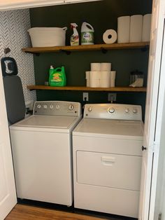 a washer and dryer in a small room with open shelving on the wall