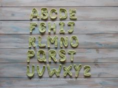 the letters and numbers are made out of green plastic yarn on a wooden background with white wood planks