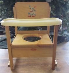 a wooden high chair with a potty seat