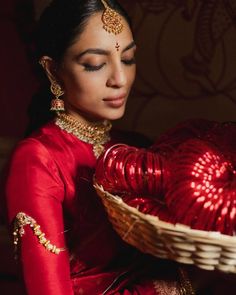 a woman in a red dress holding a basket with a heart shaped decoration on it