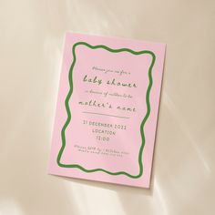 a pink and green baby shower is on the bed with its name printed on it