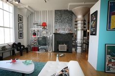 a living room filled with furniture and a fire place next to a wall mounted tv